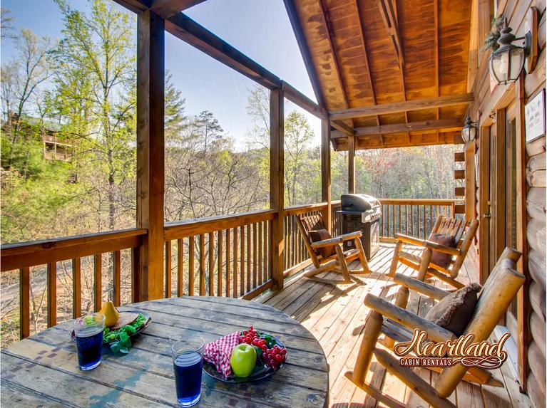 Back deck area with gas grill and wooden rocking chairs